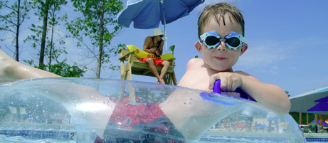 boy on clear water park tube